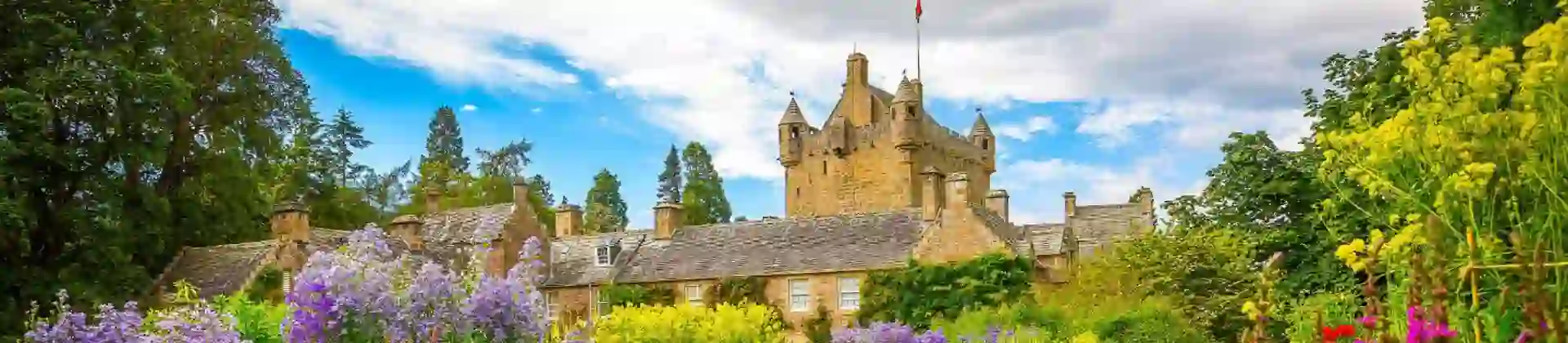 View of Cawdor Castle from the gardens, with colourful flowers and greenery in the forefront