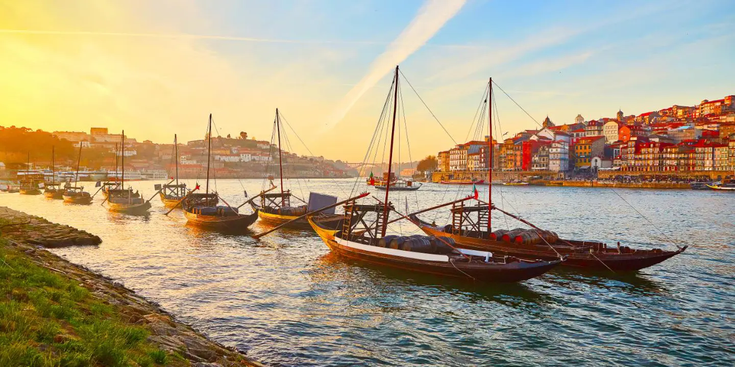 Traditional Wooden Boats, Called Barcos Rabelos Transporting Wine Barrels On The River Douro