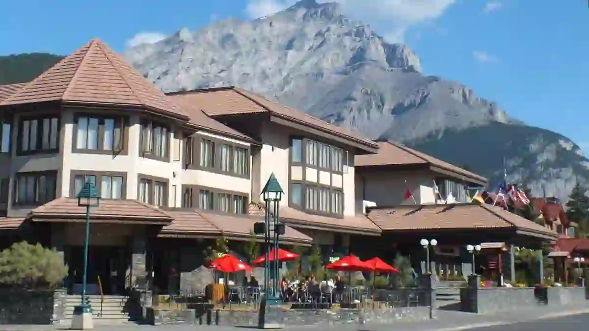 Elk and Avenue Hotel in Banff, featuring a blend of rustic and modern architecture with natural stone accents, large windows, and alpine-inspired design elements surrounded by mountain scenery