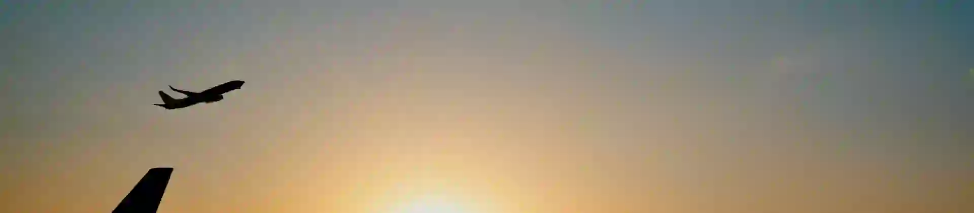 Airplane taking off at sunset over an airport