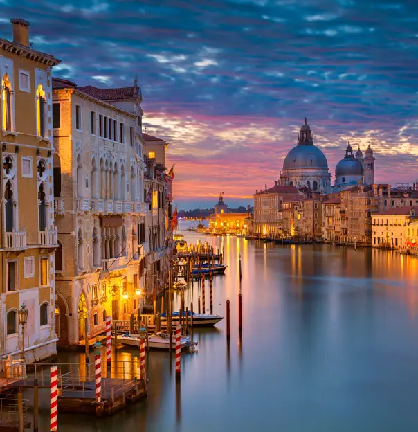 View of Venice at sunset, showing the Salute Church and a canal leading out to sea