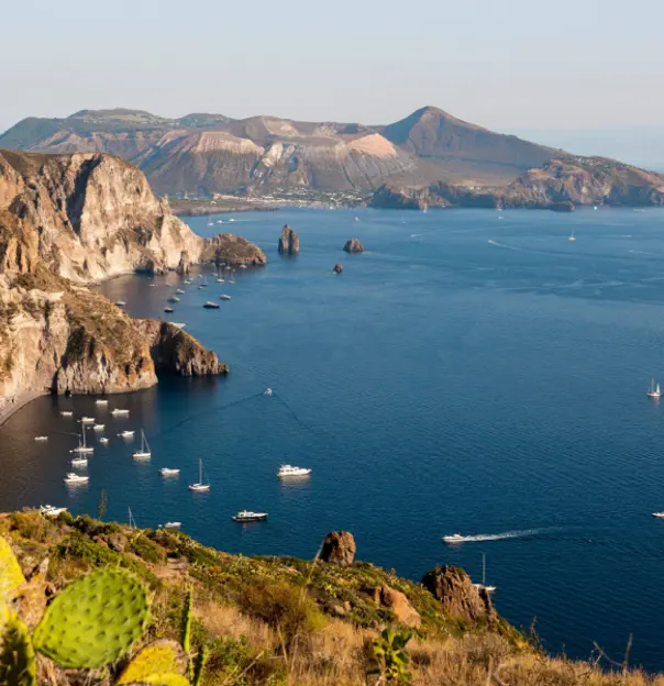 View of Quattrocchi with boats on the water and cacti in the forefront