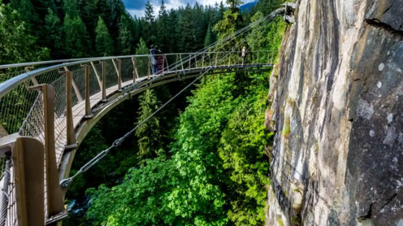 Beautiful Capilano Cliff Walk Suspension Bridge with Tourists Enjoying the View, in Vancouver.