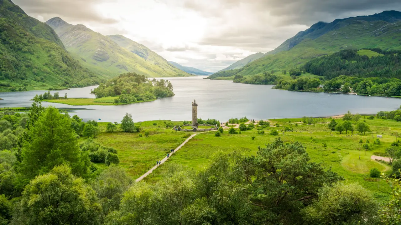 Zoomed out image of Glenfinnan Monument, with the view of Loch Shiel and the surrounding mountains