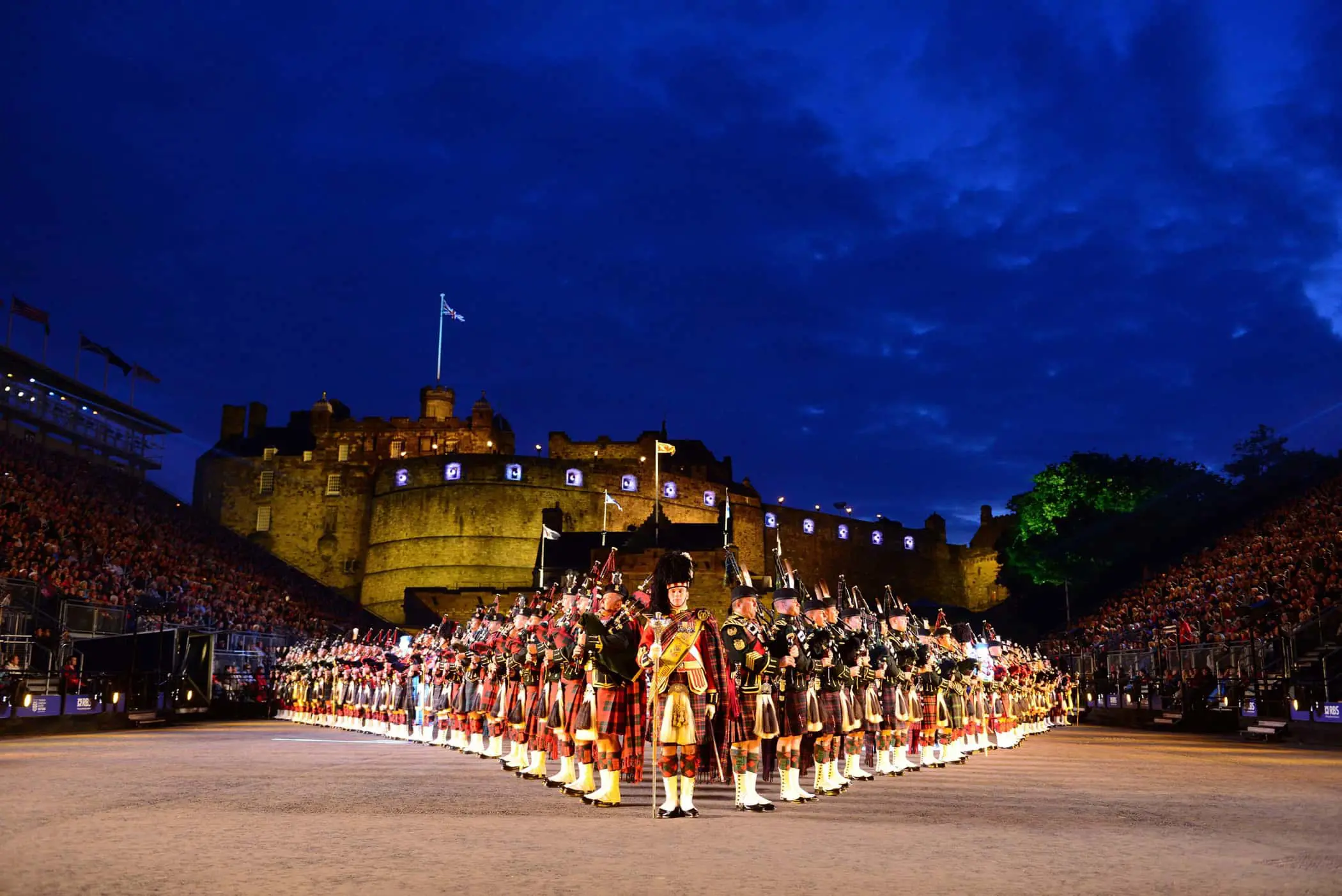 The Royal Edinburgh Military Tattoo lined up in formation infront of Edinburgh castle night time