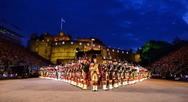 The Royal Edinburgh Military Tattoo lined up in formation infront of Edinburgh castle night time