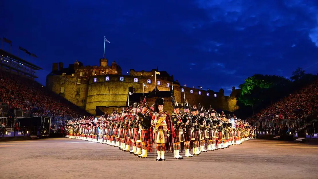 The Royal Edinburgh Military Tattoo lined up in formation infront of Edinburgh castle night time