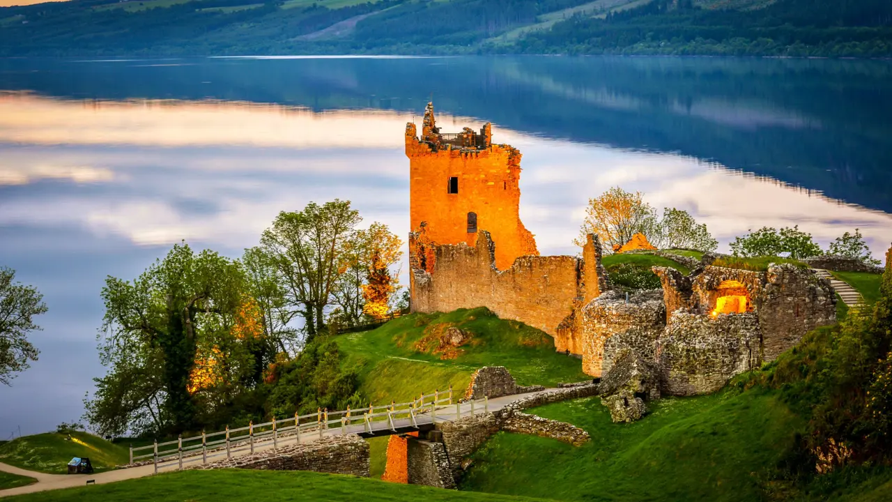 View of Urquhart Castle and Loch Ness, with the sun shining on the castle