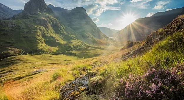 View of the Scottish Highlands with sunshine coming through behind them