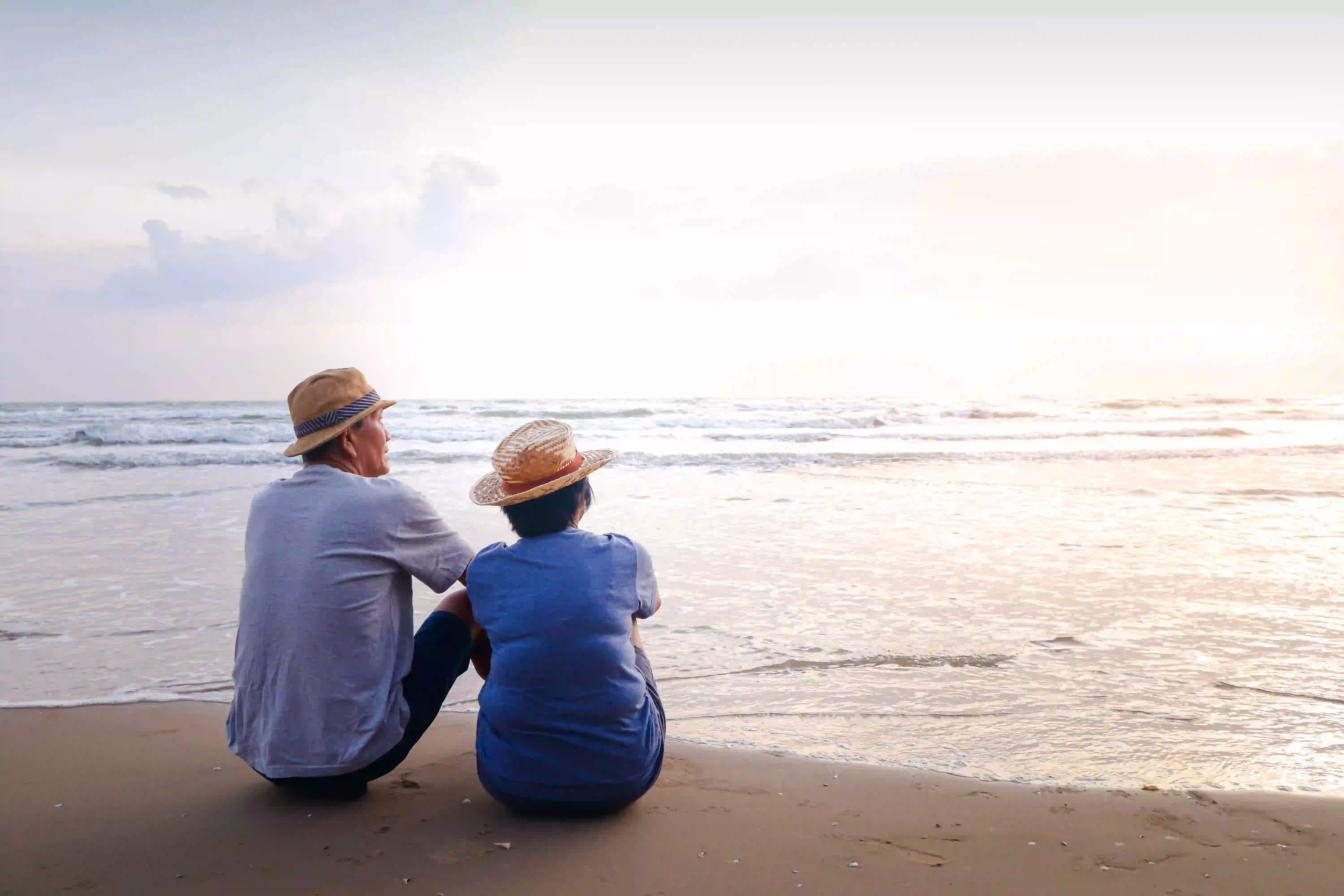 Over 60s couple sitting on the beach 