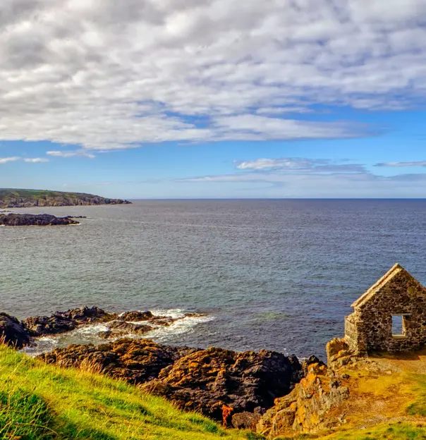 View of Moray Firth inlet, with grass and ruins of a building in the forefront