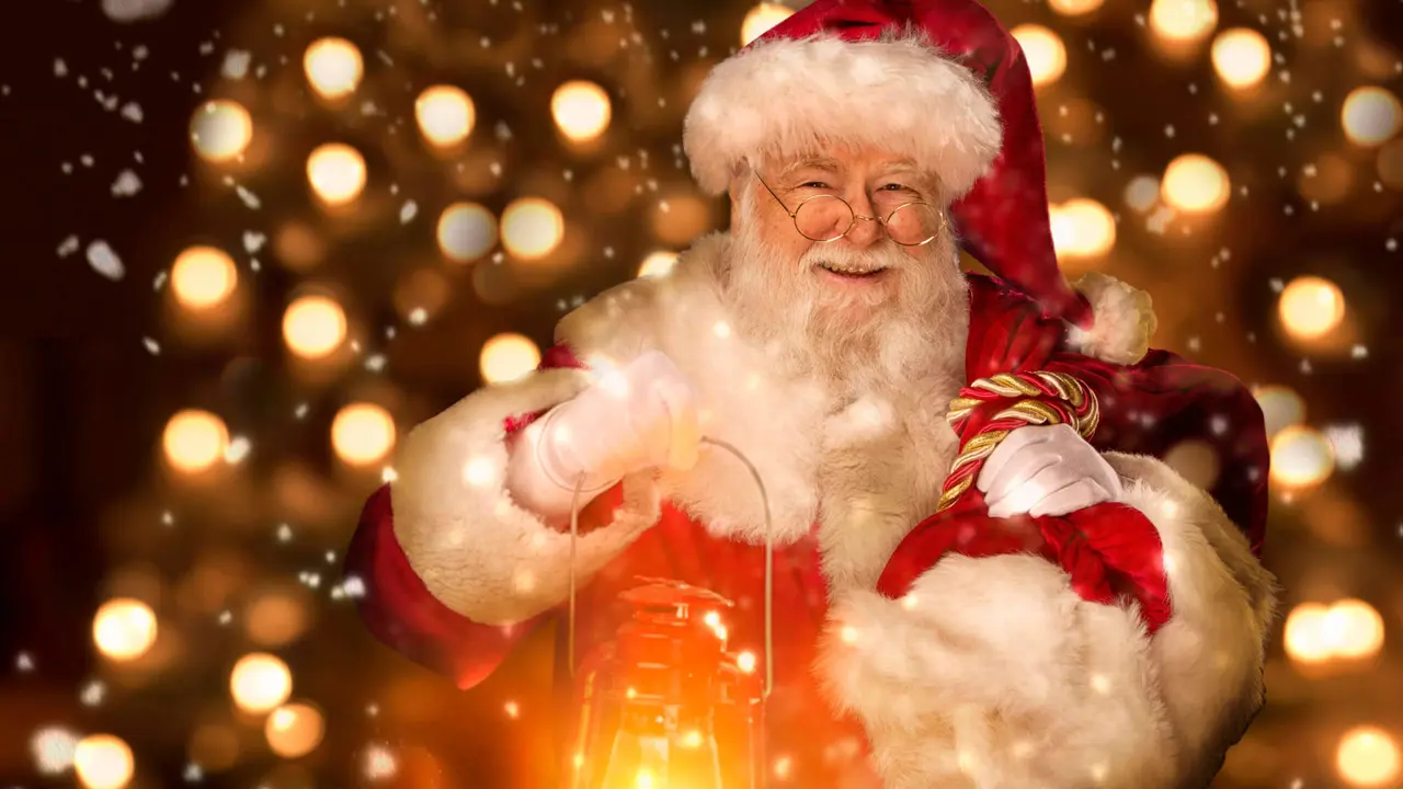 Santa holding a lantern and smiling, with a background of fairy lights