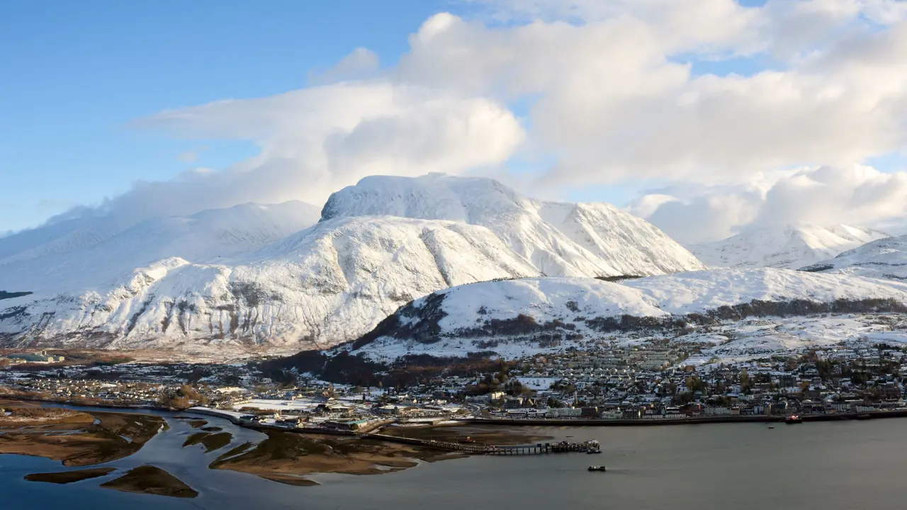 View of Fort William village with snowy Ben Nevis mountain behind 