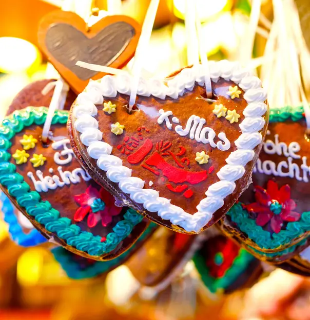 Close up of heart shaped, chocolate Christmas treats hanging on some string. 