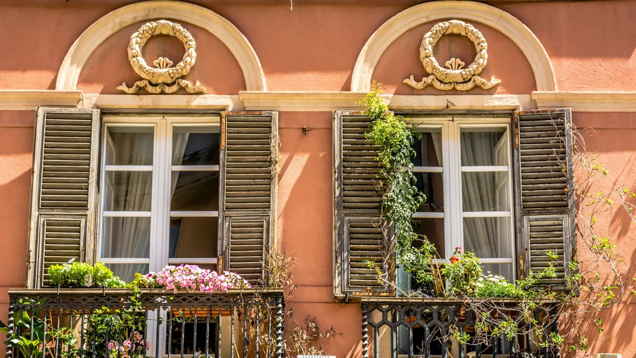 Typical windows and a colorful wall of a historic building in the historic center of the city of Cagliari, Sardinia, Italy