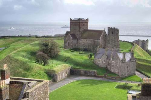 A peek at Dover castle including the St Mary of Castro church and the sea.