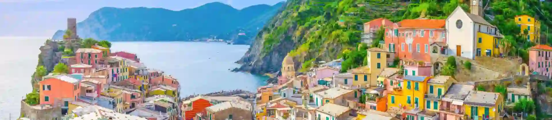 Scenic view of Vernazza, a colourful coastal village in Cinque Terre, with blue sea and a mountains in the distance