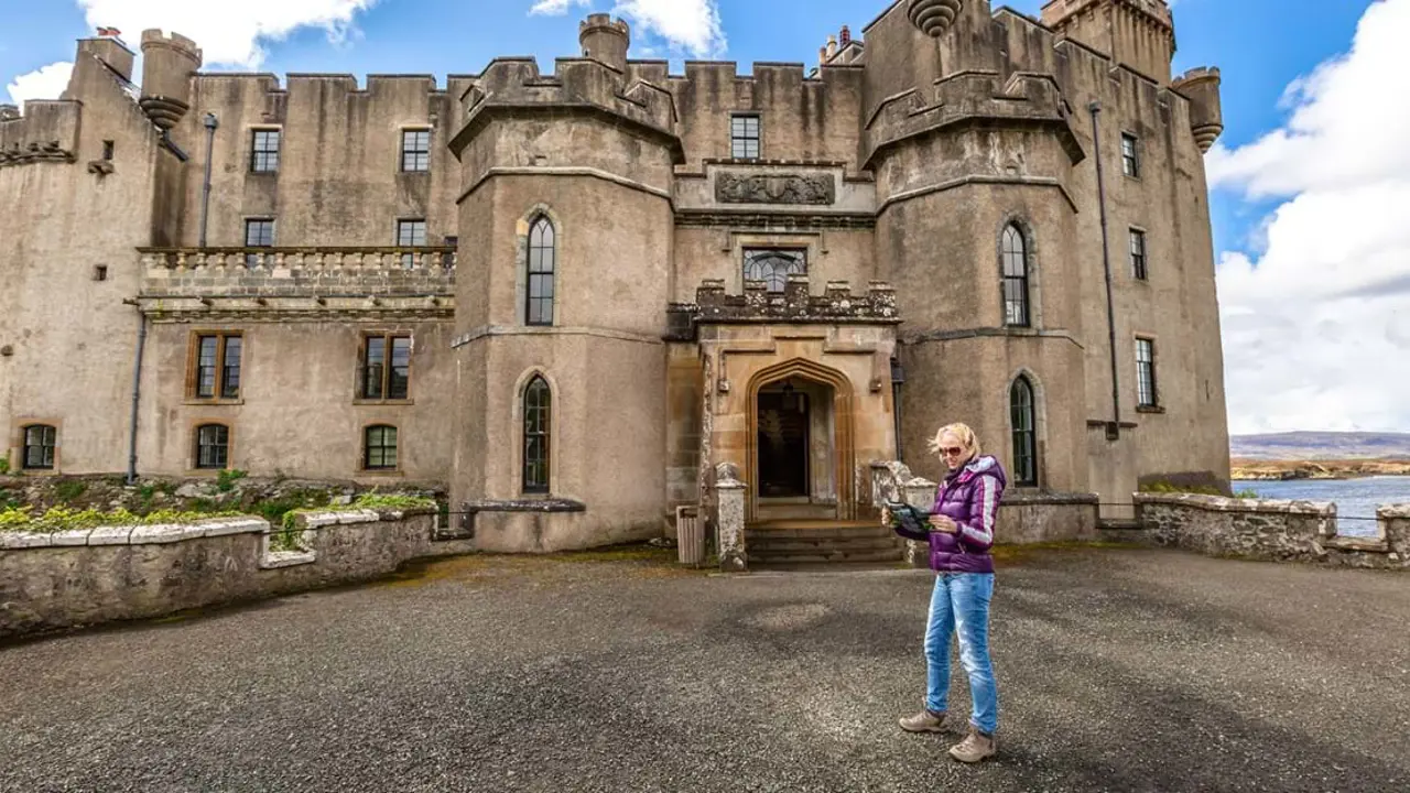  Dunvegan Castle and a lady standing outside it